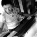A woman works on a old traditional woven machine