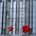 A man builds a scarffolding made with sticks of bamboo on a high building.