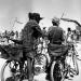 A couple disguised with leopard clothes on bike during sandstorm in black rock city.