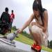 Un femme caresse un perroquet du Gabon dans un parc.