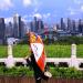Un touriste fait des tirements dans un parc en observant les gratte-ciel de Shenzhen. 