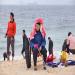 Un chinois ge est assise sur une chaise sur la plage de Shenzhen pendant que le reste de la famille s