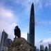 Un homme assis sur un rocher dans un parc public regarde le nouveau plus grand gratte-ciel de Shenzhen qui culmine  442 mtres