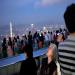 Des touristes regardent un avion passer dans le ciel  Hong Kong