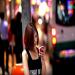 Une femme regarde son iphone claire par les enseignes lumineuses dans les rues de Hong Kong