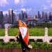 Un touriste fait des tirements dans un parc en observant les gratte-ciel de Shenzhen. 